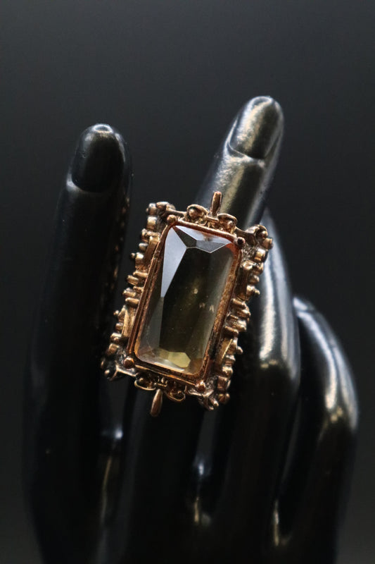 VICTORIAN STYLE EMERAL CUT AMBER COLOR GLASS STONE IN BROZE COLOR METAL BAND WITH SCROLLWORK COCKTAIL RING SIZE 7